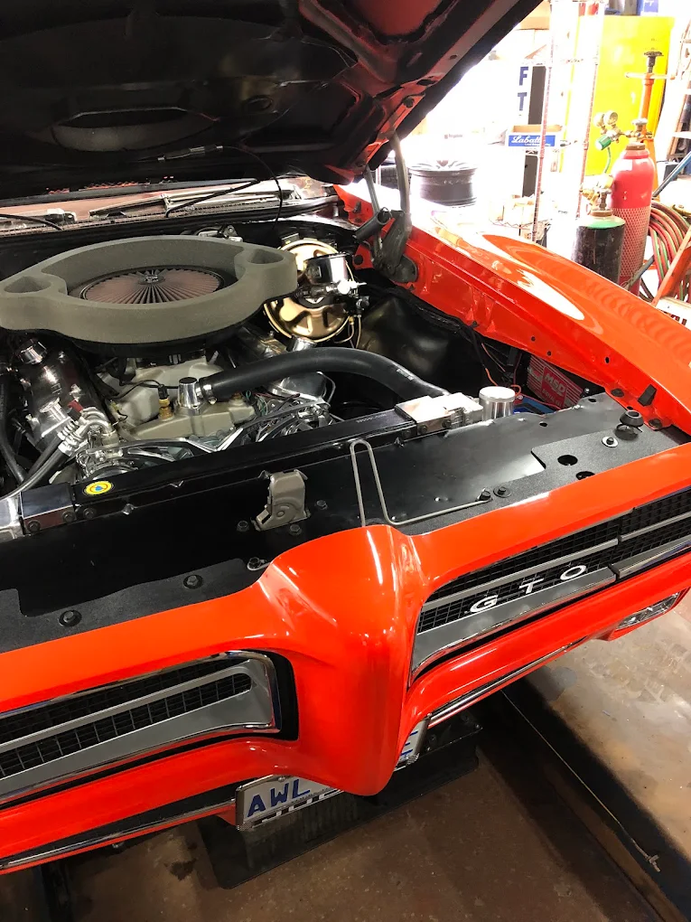 Pontiac GTO engine bay with the hood up during work at Pete's Muffler